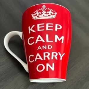 Red ceramic mug featuring the iconic British "Keep Calm & Carry On" slogan